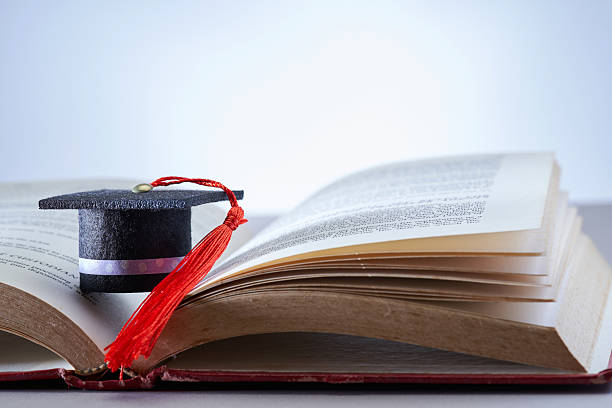 istock A book is open to a page with a small mortarboard on it. 2232362581
