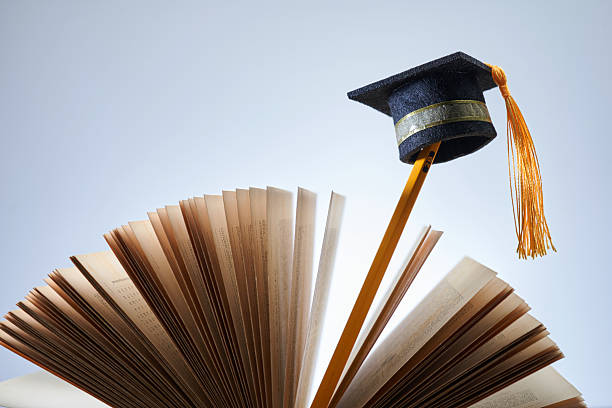 Three hands hold up words saying 'We love education'  against a darkly patterned background with copy space. The more you know, the better, whether at school or work!