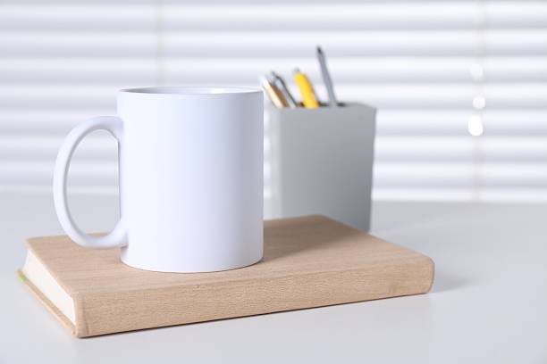 istock One blank ceramic mug and stationery on white table. Mockup for design 2232362722