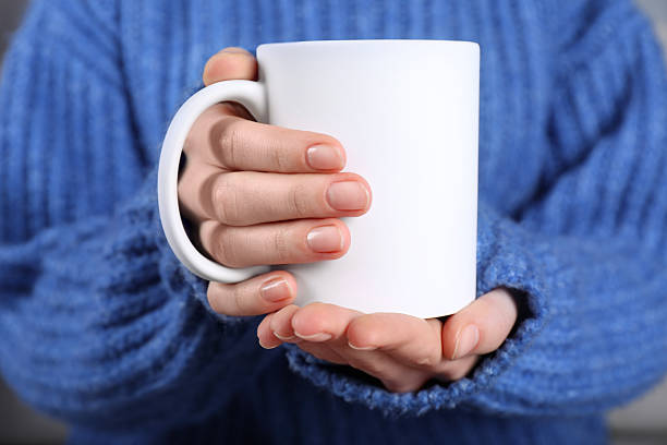 istock Woman holding blank white ceramic mug, closeup. Mockup for design 2232362844