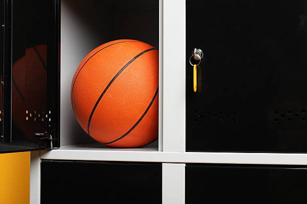 istock Open locker with basketball ball on orange background, closeup 2232362927