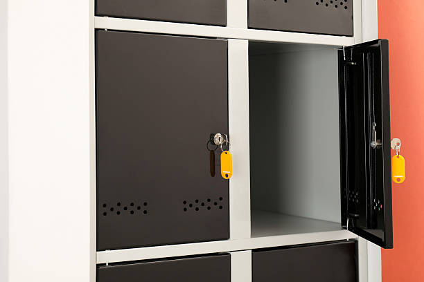 istock Modern lockers with keys on coral background, closeup 2232362940