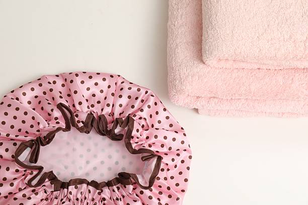 close up of body and back scrubbers for shower with plastic handle and yellow soap on pink towel