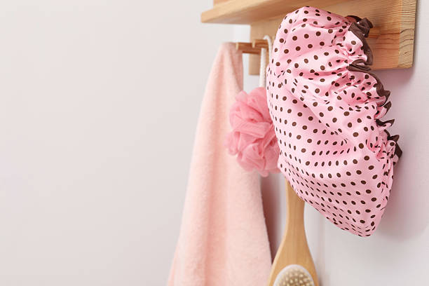 istock Shower cap, brush, mesh sponge and towel on rack indoors, space for text 2232363737