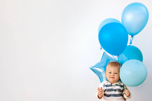 istock Baby Holding Balloons – White Wall Background 2232363962