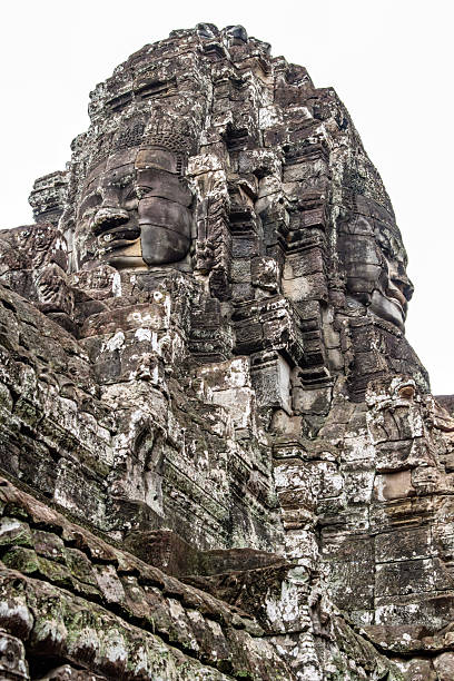 A detailed view of intricately carved stone faces at Angkor Thom, a renowned Khmer temple in Cambodia. The ancient architecture and cultural significance attract visitors seeking historical and spiritual experiences.