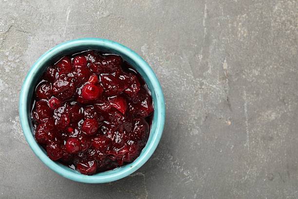 istock Tasty cranberry sauce in bowl on grey table, top view. Space for text 2232364280