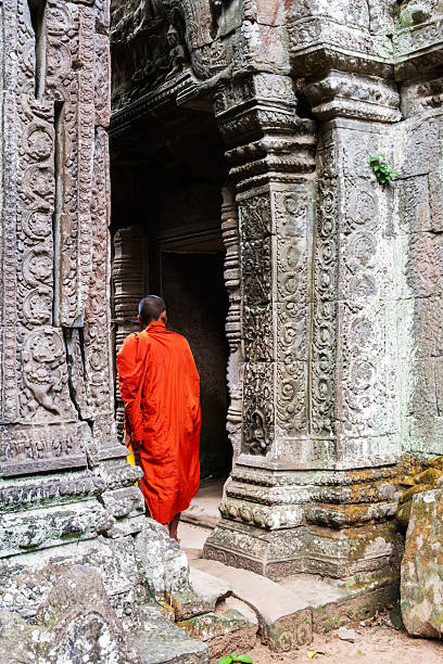 Headshot  portrait of tall thai monk in scene  outside of Wat Phrathat Doi Wiang Chai Mongkhon วัดพระธาตุดอยเวียงชัยมงคล – Temple Thai  Ping Khong, Chiang Dao District. Monk is head monk and running the temple inlcuding its restoration. Temple is more than 700 years old. Monk is talking to people and visitors of the temple and explaining history of place.