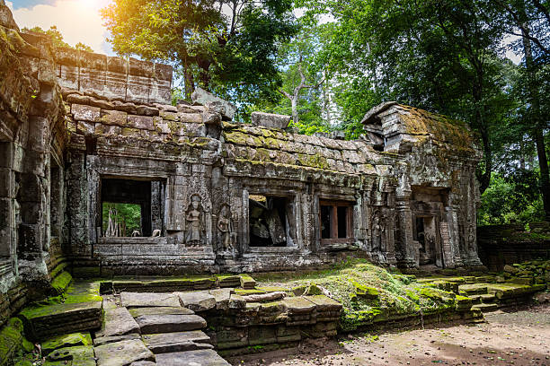 The captivating Ta Prohm Temple at Angkor Archaeological Park, Cambodia, prominently features ancient architecture intertwined with massive tree roots, showcasing the harmonious fusion of history and nature in this iconic destination.