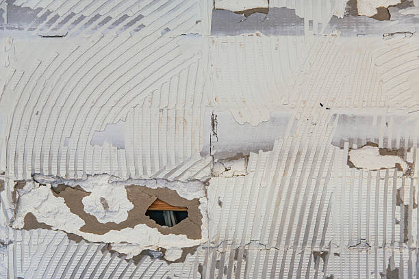 istock Kitchen wall rough surface adhesive remnants after tile removal holes and imperfections visible 2232370280