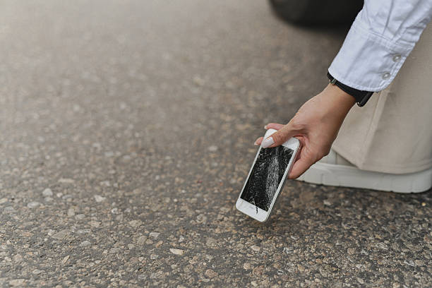 Female Holding Damaged And Broken Smartphone After Dropping It On Road