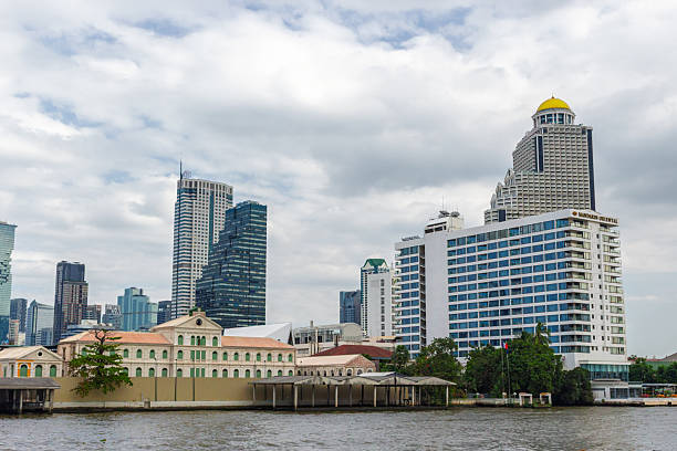 Bangkok, Thailand - 30 December, 2023: cityscape of Bangkok city and Chao Phraya river. Modern hotels and glass high-rise buildings around historical building under restoration