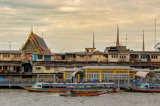 Bangkok, Thailand - 29 December, 2023: view on boats moored on Tha Tien Pier the Chao Phraya River in Bangkok, Thailand. Tourist excursions and cruise on boat along the river are popular