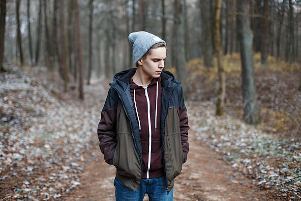 Young handsome man walking in the autumn forest