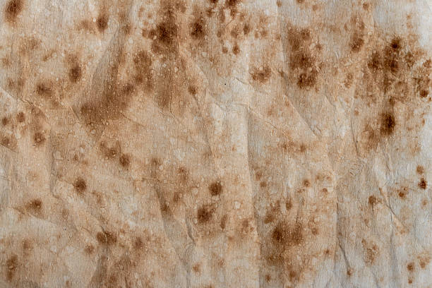 istock old brown paper with grunge spots - texture background 2232375219
