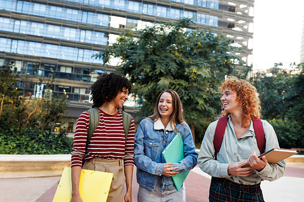 istock Cheerful university students walking and talking together on campus 2232375493