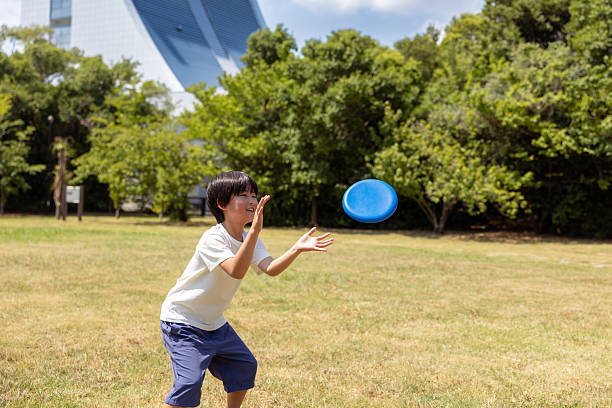 Little boy catching a flying-disc in public park