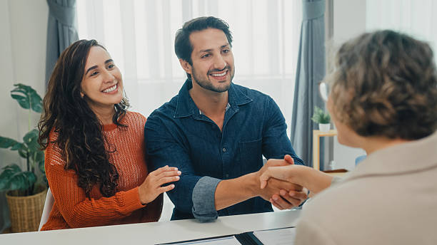 istock Financial advisor using tablet discussing about life insurance domestic finances and handshake agreement with young couple in living room at home. Financial planning and lifestyles concept. 2232376568