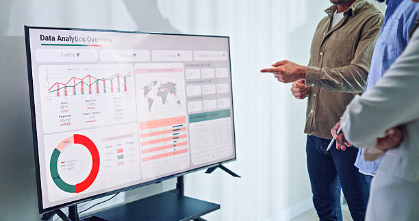 istock Closeup group of business professionals meeting discussing data analytics during a presentation, discussing strategy and growth standing at the office. Finance meeting concept. 2232377734