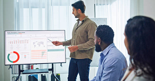 istock Group of business professionals meeting reviewing global data analytics discussing data analytics during a presentation, discussing strategy and growth standing at the office. Finance meeting concept. 2232377760