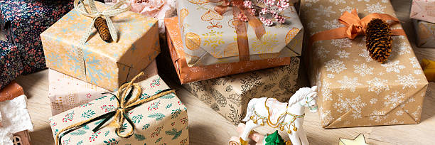 Rustic-themed Christmas gift boxes in natural tones resting beneath a Christmas tree, surrounded by a calm, minimalist holiday atmosphere, banner