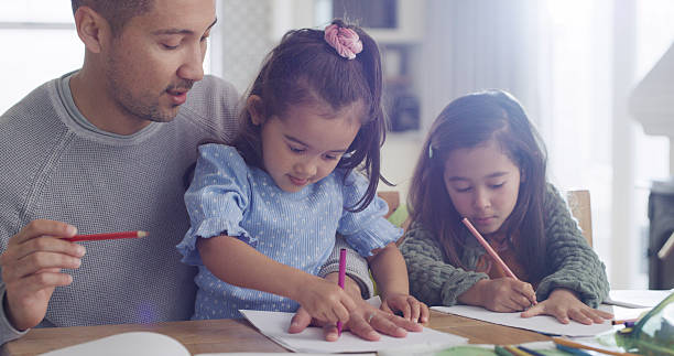 istock Drawing, creative and dad with children in home for learning colors, activity and homework together. Family, bonding and father with girls trace hands on paper for education, development and help 2232381641
