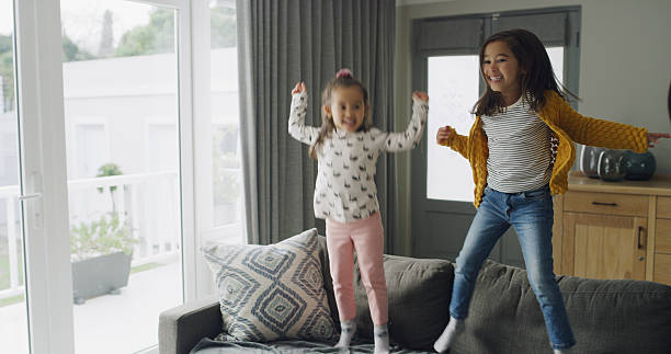 istock Jumping, playful and ADHD with kids on sofa for hyperactivity, energy and bonding. Sensory stimulation, dancing and entertainment with children in living room of home for funny and game together 2232381716