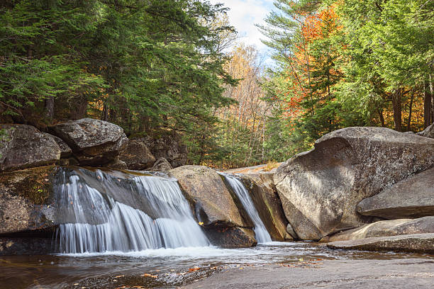 Waterfall in a forested mountain setting on a sunny autumn day. Grafton Notch, ME, USA.