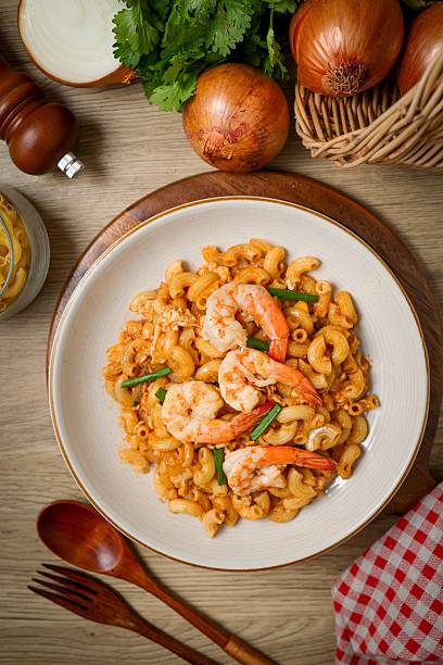 Homemade Stir fried macaroni with shrimp and egg in white plate