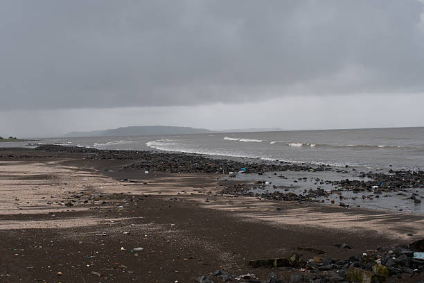 istock vasai sea beach with dark clouds and rocky shoreline 2232387976