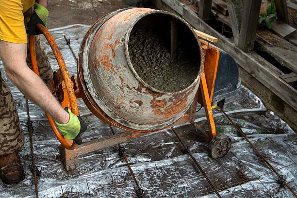 istock A man mixes concrete in a small orange cement mixer 2232391298