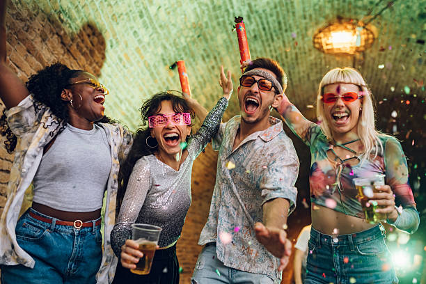 istock Young people celebrating with confetti and drinks at a lively party 2232391378