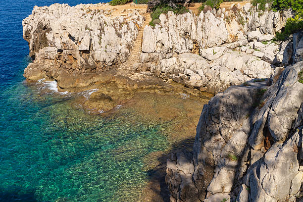 istock A hidden stone staircase winds down rugged cliffs to the crystal-clear turquoise waters of Saint-Jean-Cap-Ferrat, French Riviera. 2232394430