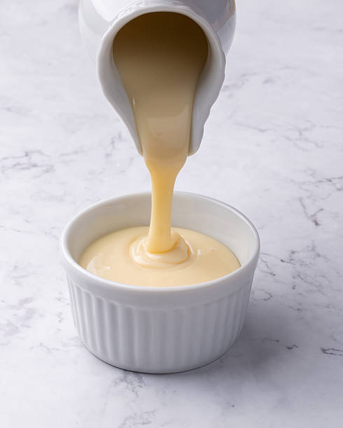 istock Pouring condensed milk in a bowl over marble background 2232398563