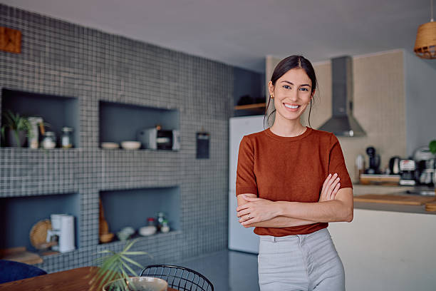 istock Young Woman Smiling with Arms Crossed in Modern Kitchen 2232398767