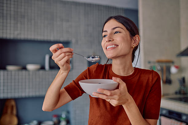 istock Young woman enjoying a healthy breakfast in her modern kitchen 2232398811
