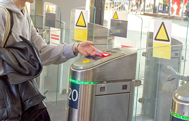 istock Young man scanning QR code on train ticket on turnstile scanner to board train at train station 2232401915
