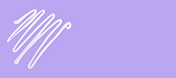 Cream lines on violet lavender background with copy space, cream texture suggests skincare, softness and calm. Cream highlights beauty, cream supports wellness visuals and cosmetic product branding