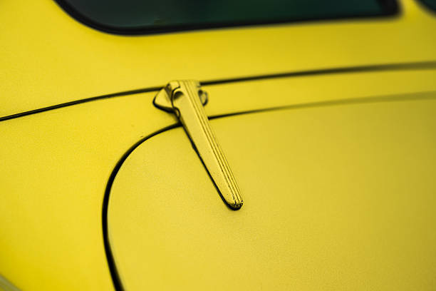 Yellow classic car trunk with chrome hinge.