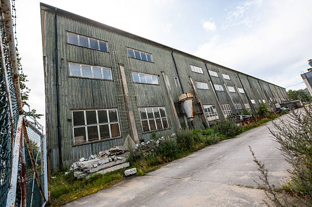 istock Abandoned green industrial warehouse with broken windows.. 2232404538