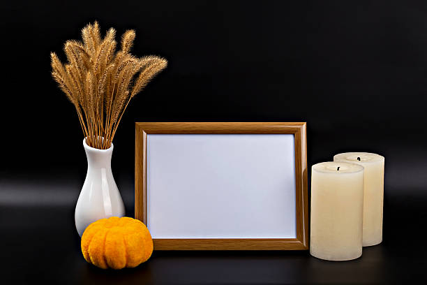 istock Autumn themed display with empty frame, decorative pumpkin, candles and dried grass in cozy arrangement 2232405230