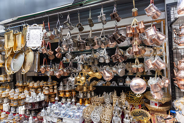 Traditional handcrafted, colorfully embroidered copper coffee pots and water mugs. Copper coffee pots hanging in a gift shop window. Turkish handicrafts. Grand Bazaar - Spice Bazaar. Istanbul - Turkey