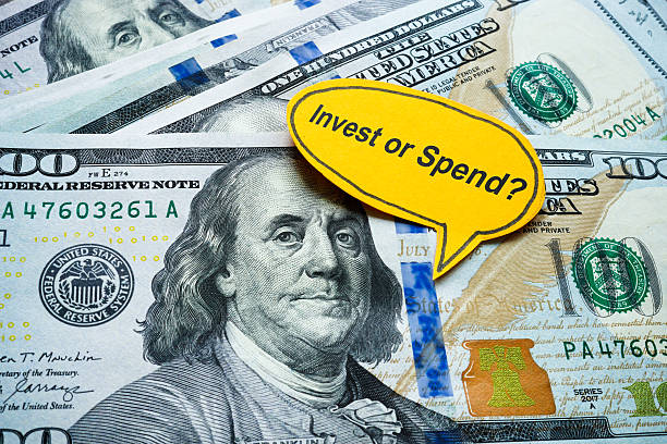 istock Money with the words invest or spend. Financial decision making. 2232408749