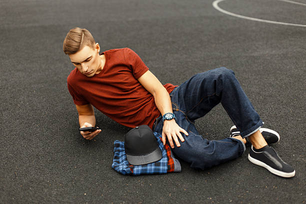 istock Modern handsome man uses the phone and lying on the pavement. 2232410529