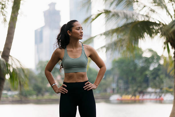istock Determined sportswoman posing with hands on hips in a tropical park 2232411206