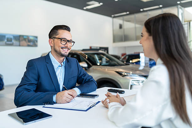 istock Car salesman explaining vehicle features to customer in showroom 2232411234