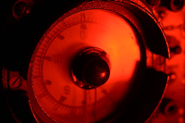 Close-up of a vintage analog altimeter gauge glowing red in the dark, showing retro aviation instrument design and mechanical detail.