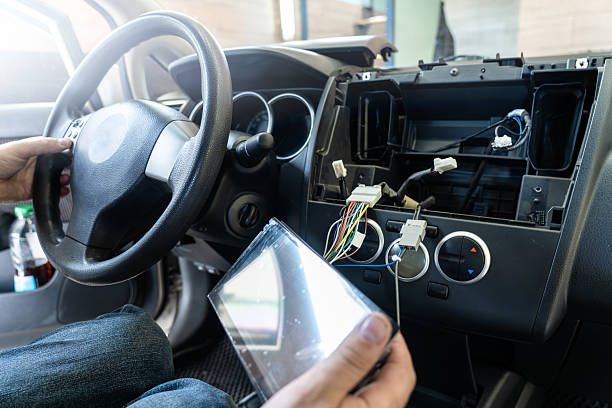 istock Repairman replacing car multimedia unit and working with dashboard wiring, vehicle electronics upgrade, automotive repair 2232417153