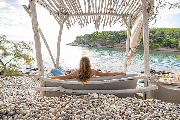 istock Woman Relaxing on Beachside Swing Sofa 2232417810