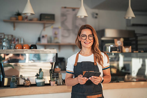 istock Smiling beautiful waitress with tablet in modern coffee shop 2232417871